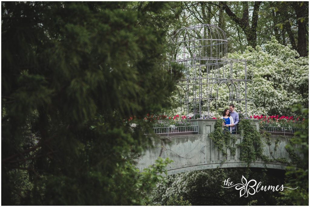 Rachel and Chris stand on a bridge at The Atlanta Botanical Garden