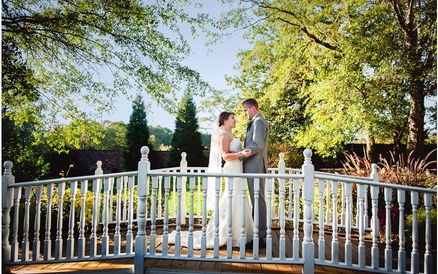 Lauren and Seth stand on a bridge at The Carl House wedding venue
